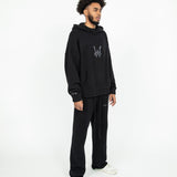 Head to toe angled side profile of the WOA Knit Hoodie in Black.The Knit Hoodie is paired with the Knit Sweatpants in black.