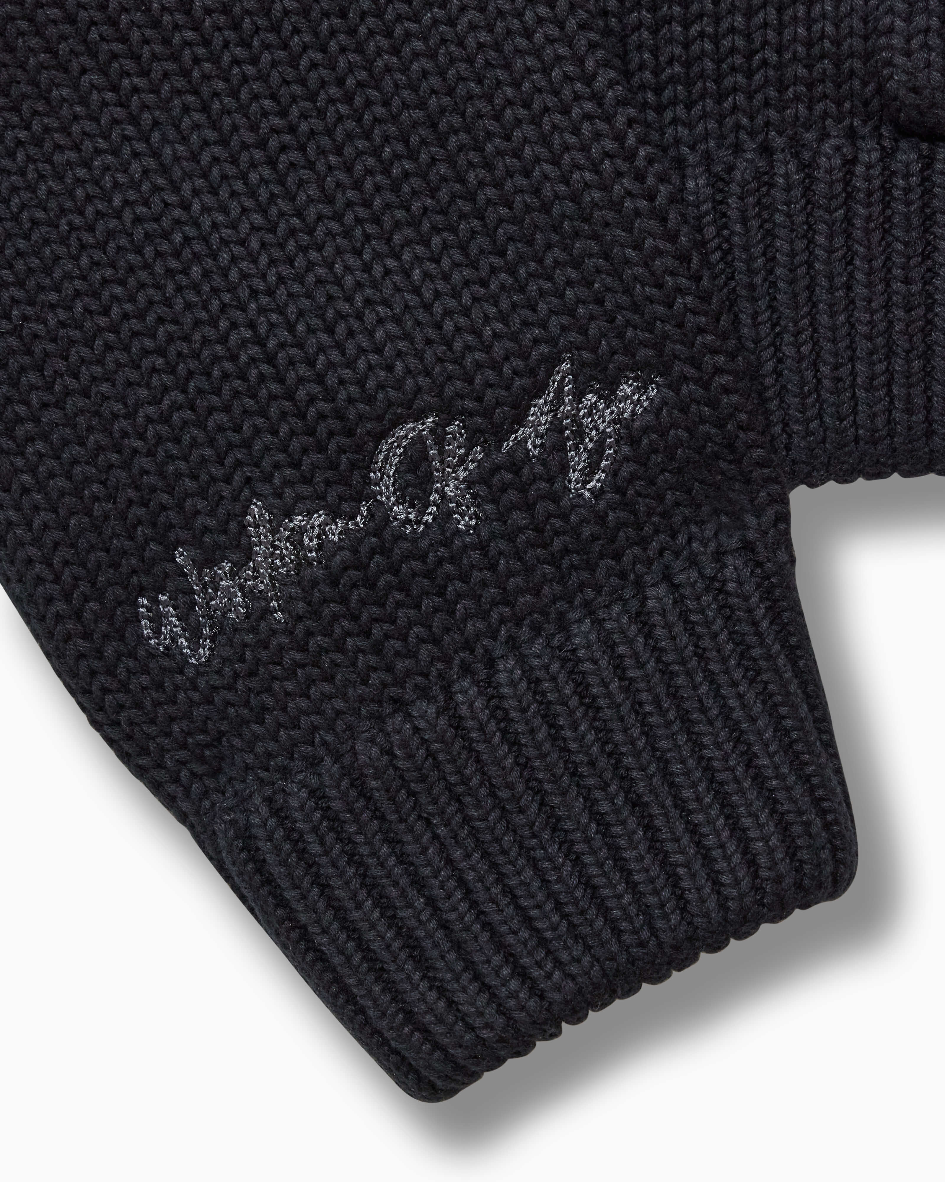 Closer look at the right sleeve with the brand name "Wisdom of Age" embroidered in a handwritten script cursive.