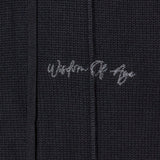 Closer look at the upper left leg with the brand name "Wisdom of Age" embroidered in a handwritten script cursive.