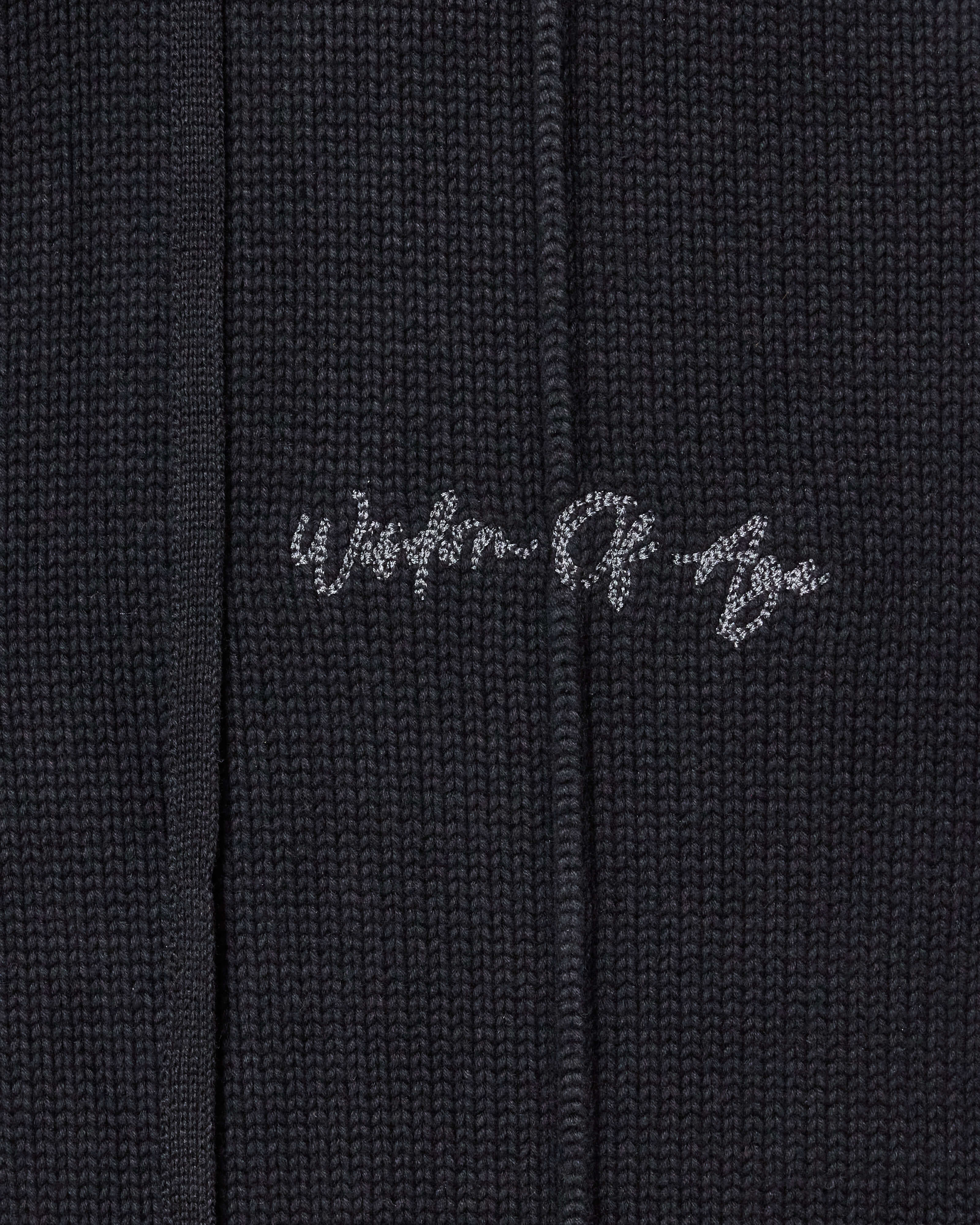 Closer look at the upper left leg with the brand name "Wisdom of Age" embroidered in a handwritten script cursive.