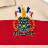 Wisdom of Age Bleecker Rugby Polo in multicolor stripes zoomed front view of embroidered ornate brand emblem .
