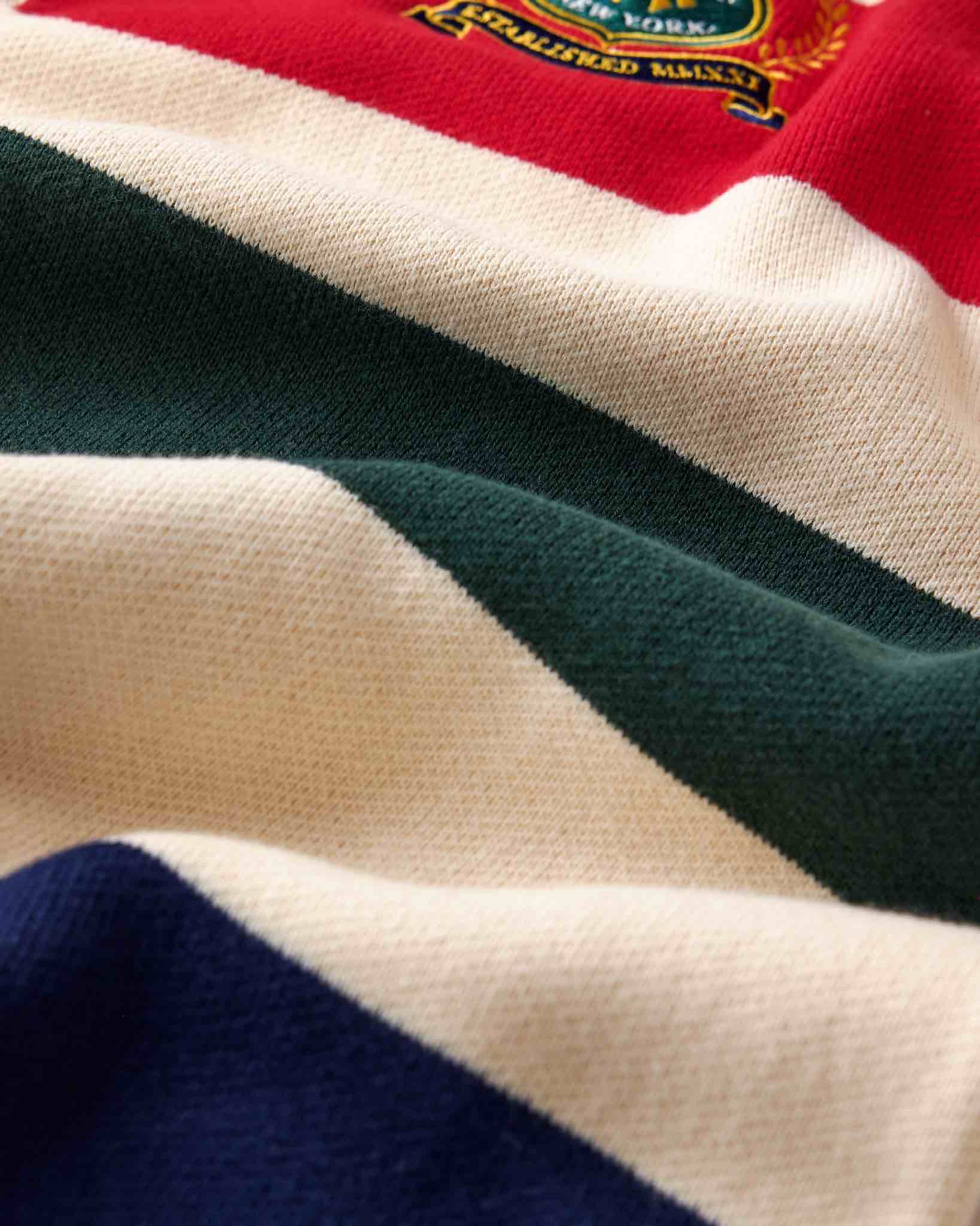 Wisdom of Age Bleecker Rugby Polo in multicolor stripes zoomed front view of premium cotton knit material and brand embroidery .