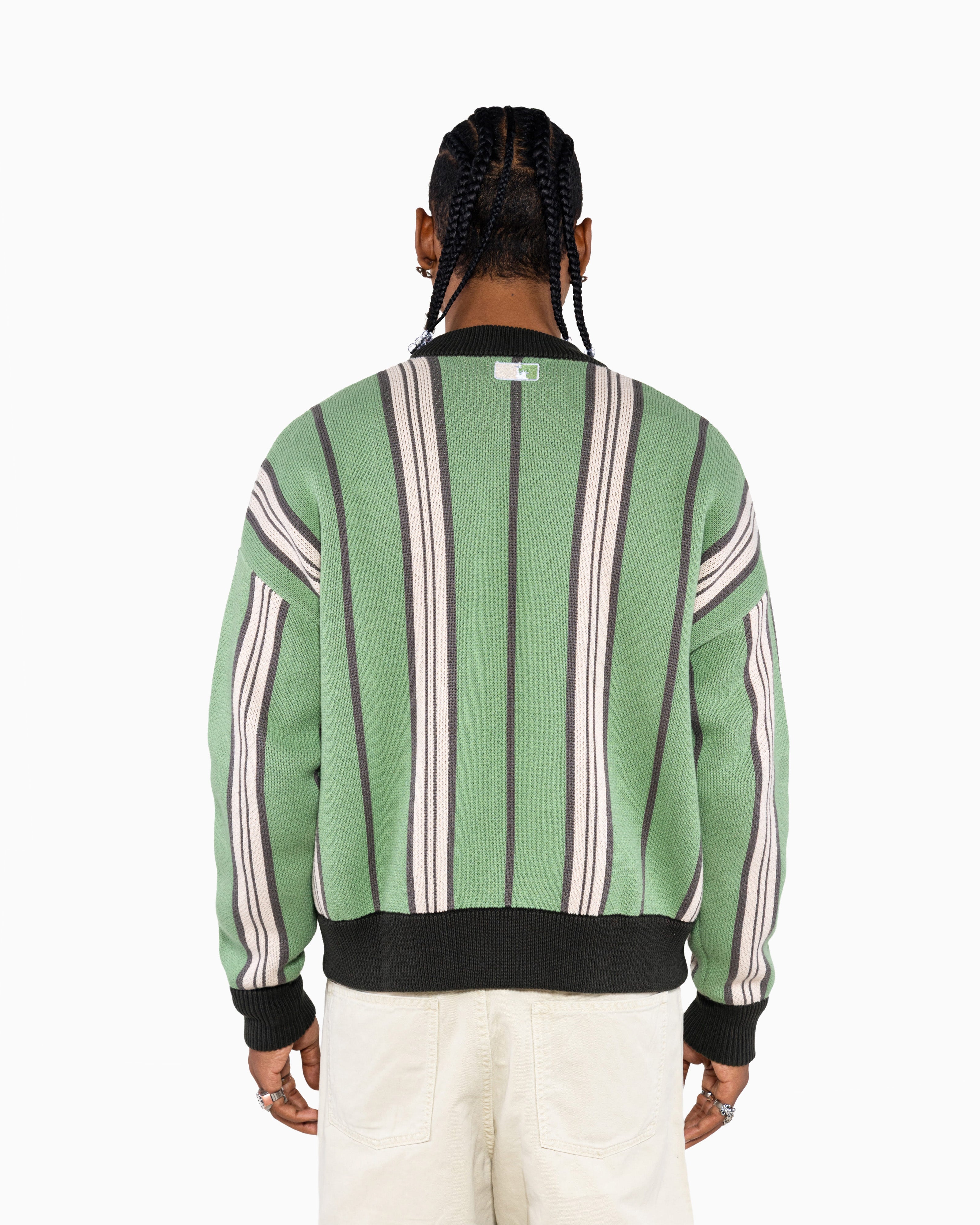 Rear view Of a Male Model Wearing the Male model wearing the Wisdom Of Age City Cardigan in Sage Green with striped pattern and WA logo on a white background
