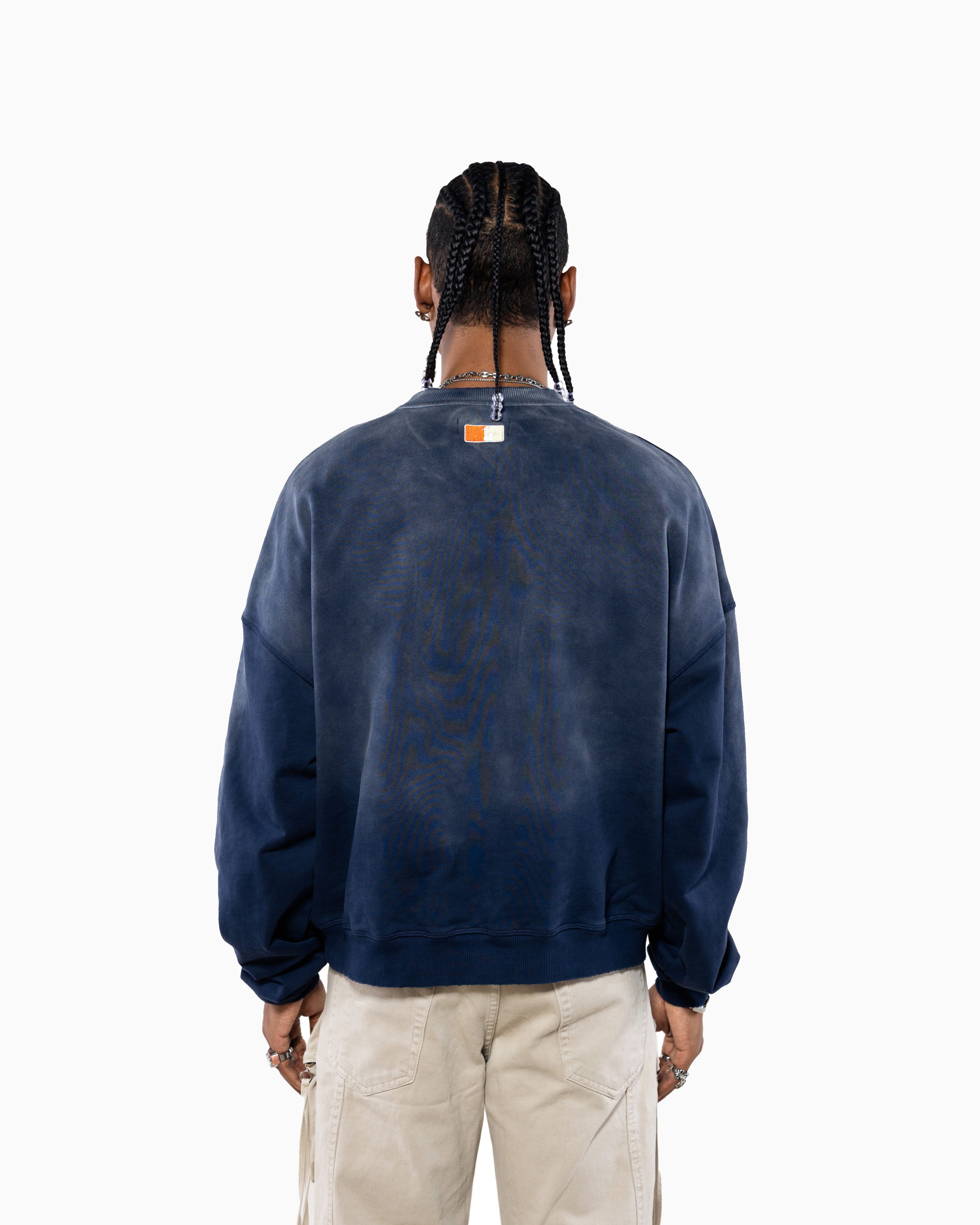 Male Model wearing a navy blue sweatshirt with the NY Tough logo on the back, standing against a white background