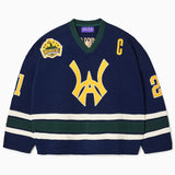 Front view of the Wisdom Of Age Knit Hockey jersey Navy. WA logo on the front with  and captains C on the left shoulder and a nyc skyline patch on the right shoulder. the number 21 on the sleeves