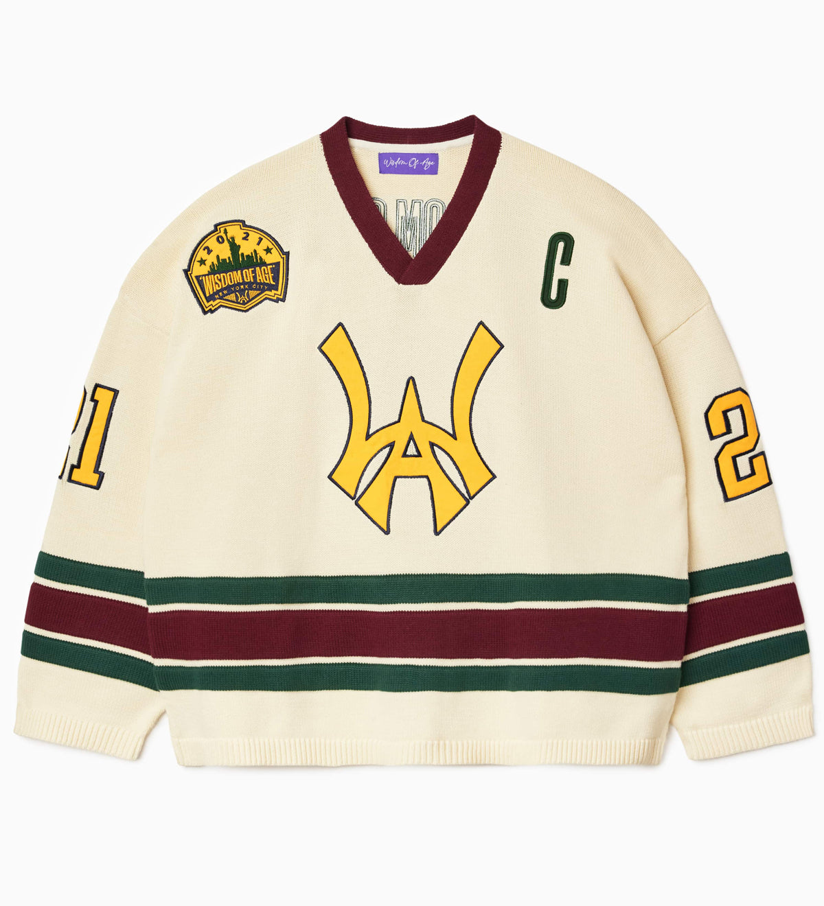 Front view of the Wisdom Of Age Knit Hockey jersey Cream V2. WA logo on the front with  and captains C on the left shoulder and a nyc skyline patch on the right shoulder. the number 21 on the sleeves