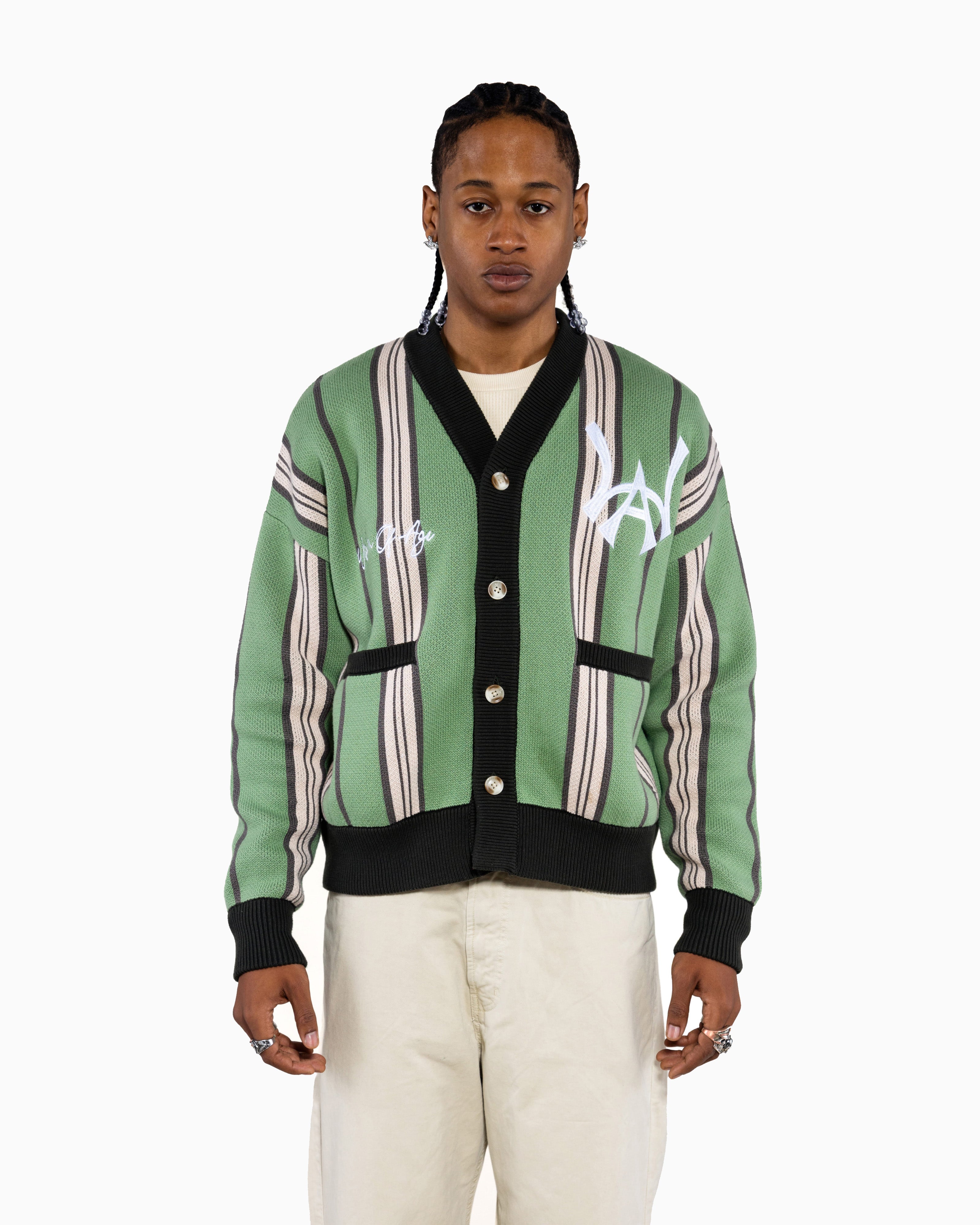 Male model wearing the Wisdom Of Age City Cardigan in Sage Green with striped pattern and WA logo on a white background