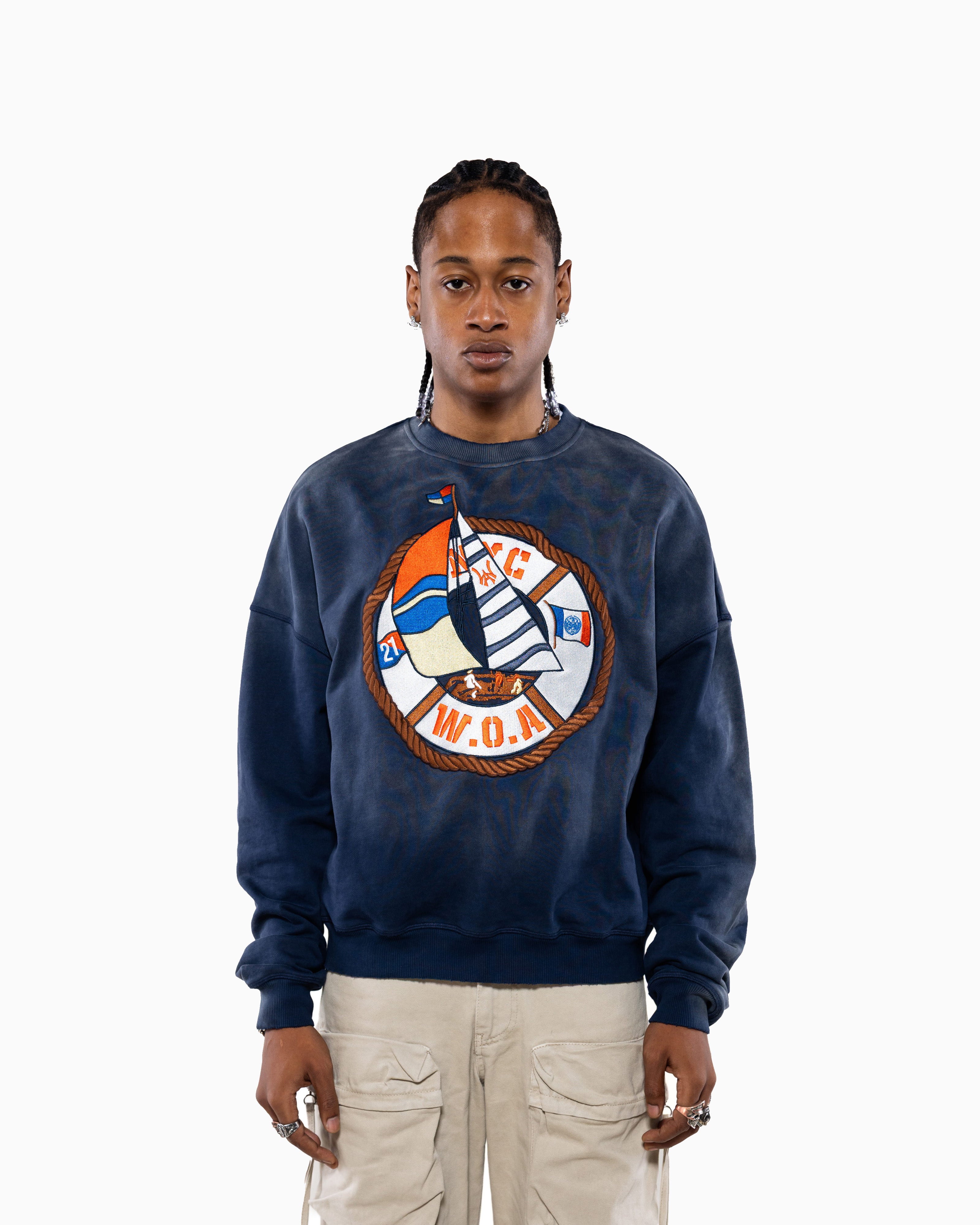 Male Model wearing a navy blue sweatshirt with a logo on a white background